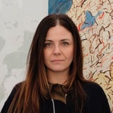 Portrait of Chiara Nuzzi in front of a contemporary artwork.
