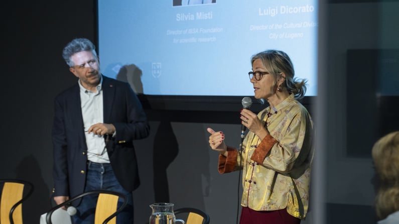 Speaker addresses the audience with a microphone during a panel on social prescribing