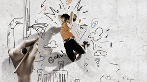 A boy playing basketball on a court that is being drawn by a hand as he plays