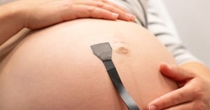 pancia di donna in gravidanza con nuovo cerotto che monitora