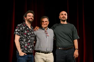 I conduttori del podcast Tintoria posano insieme all'ospite Dario Bressanini palco prima dell'inizio dell'evento a Lugano.