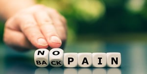 Hand turns dice and changes the expression back pain to no pain