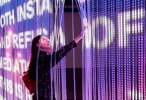 Visitatrice tra le luci LED dell’installazione Morestalgia di Riccardo Benassi.